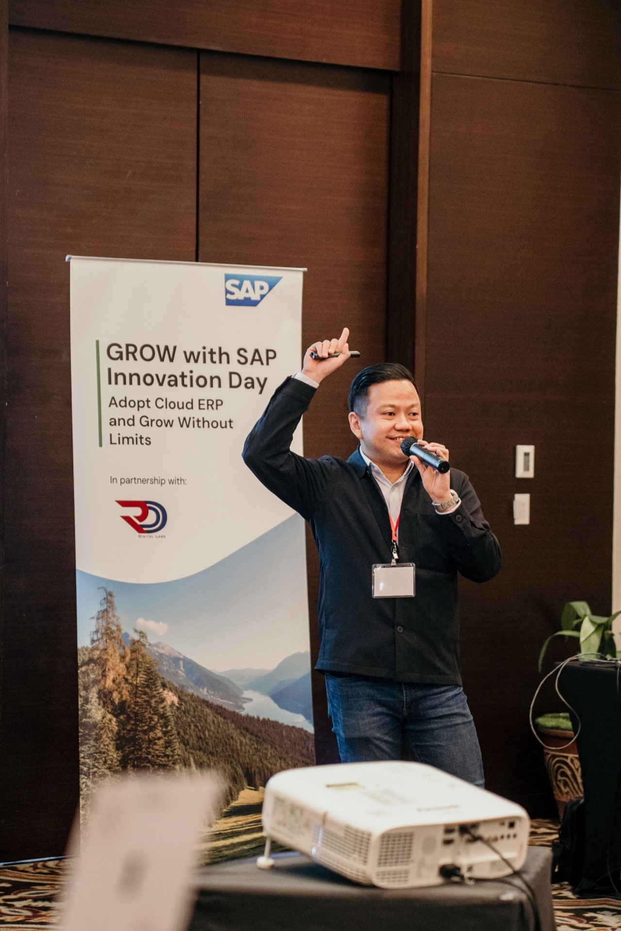 Speaker at GROW with SAP Innovation Day beside a banner showing SAP and Erendi